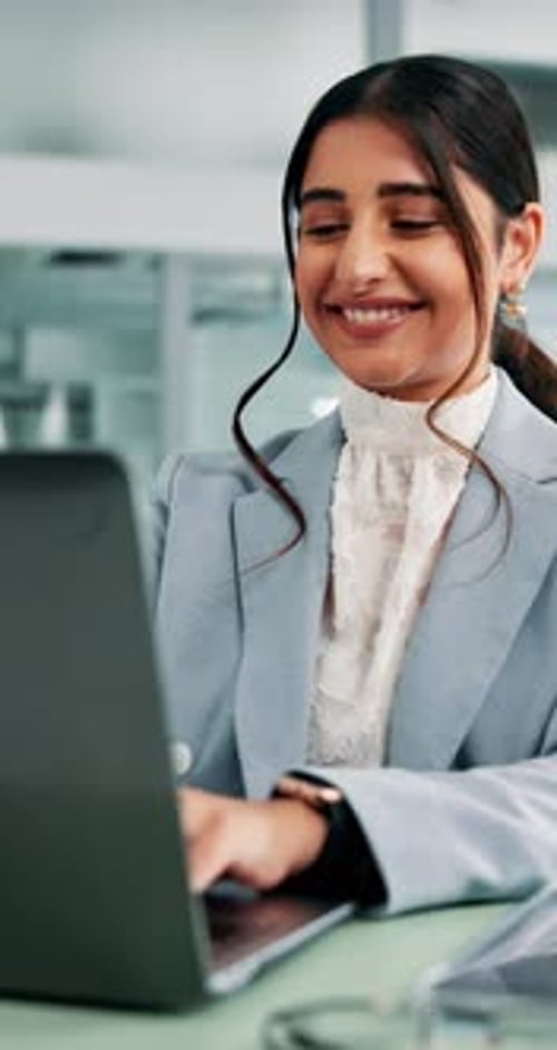 Cheerful Woman Working on Laptop in Office
