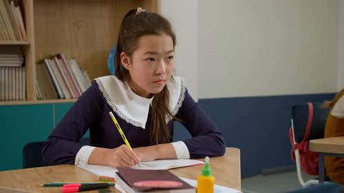 Elementary School Class Children Communicate with the Teacher Answering Question