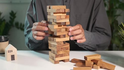 Handspielendes Spiel mit Turm aus Holzblöcken