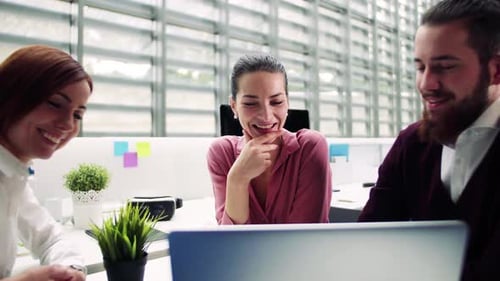 Young business team collaborating and talking together in a modern office