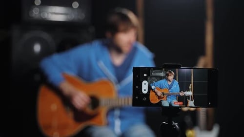 Man Records Himself Playing Guitar with Smartphone