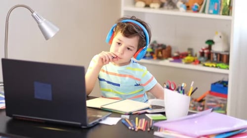 Young Boy with Headphones Studying at Desk