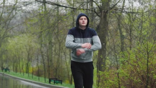 Man Warming Up in Park on Cloudy Day