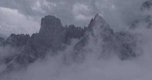 Dramatic Alpine Mountain Peaks Emerging Through Thick Clouds and Mist