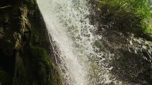Magischer Bergwasserfall, kristallklares Wasser, große, mit Moos bewachsene Steine. Der Wasserfall mit dem