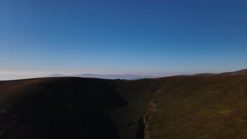 Drone survole le sommet du mont Gemba avec une chaîne de montagnes pittoresque à l'horizon, vue aérienne du
