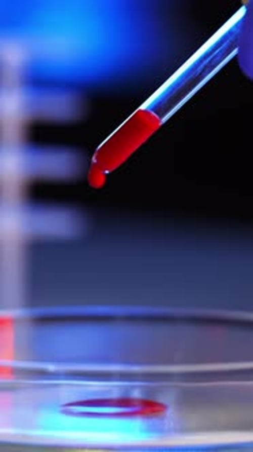Red Liquid Dripping Into Petri Dish