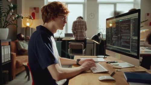Time Lapse of Young Developer Typing Code on Computer at Modern Office Desk