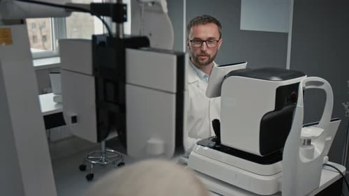 Arzt trägt Laborkittel und stellt Diagnosegerät für Sehtests auf