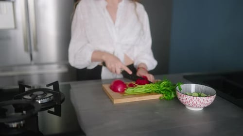 Woman in Headphones Making a Salad of Vegetables and Has Fun Dancing at Modern Kitchen Island Young