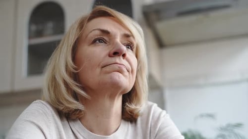 Woman Indoors Thinking and Covering Face