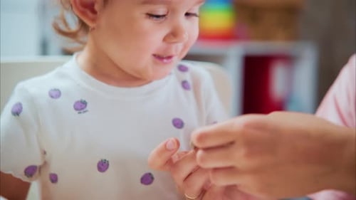 Young Girl Molding Clay with Adult Supervision