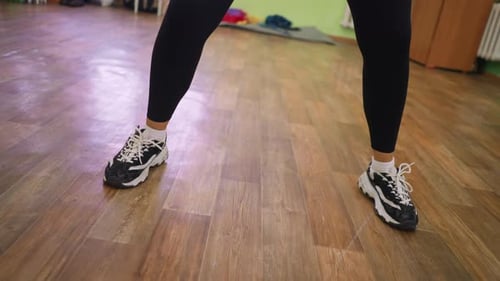 Leg View of Woman Raising Foot From Wooden Floor During Dance Workout