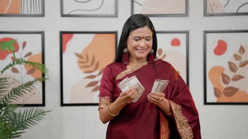 Woman Smiling, Holding Money Indoors
