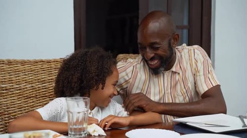 Happy Girl and Man Laughing at Table