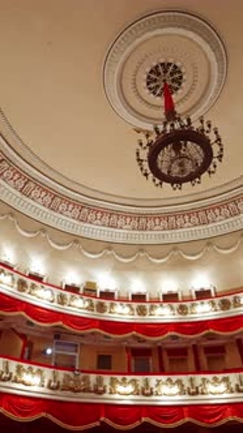 Selective focus on empty rows with red velvet seats in theater hall. Rows with empty chairs