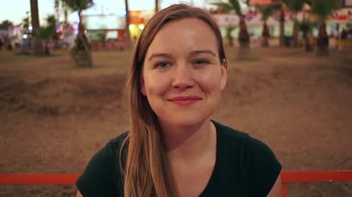 Woman Smiling Cheerfully Outdoors at Night