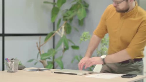Man Arrives at Desk and Begins Working on Laptop