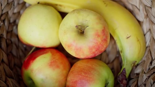 Ein wunderschöner Korb voller frischer und bunter Früchte, darunter saftige Äpfel und reife Bananen