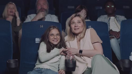Mother and Daughter Enjoying a Movie at the Cinema