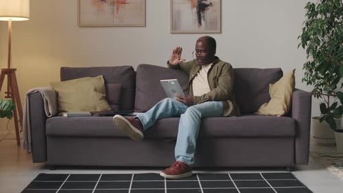 Senior Man Video Calling on Tablet from Home