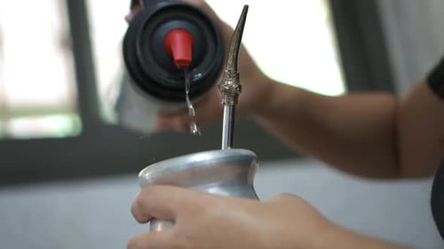 Traditional process of serving mate (yerba mate infusion).