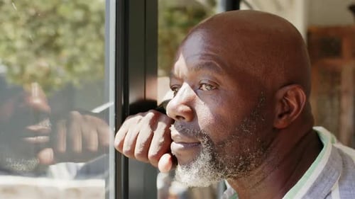 Man Gazing Out the Window Reflectively During the Day