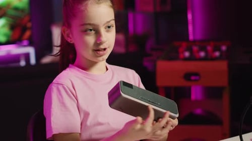 Girl Demonstrating Portable Speaker in Purple Lit Room