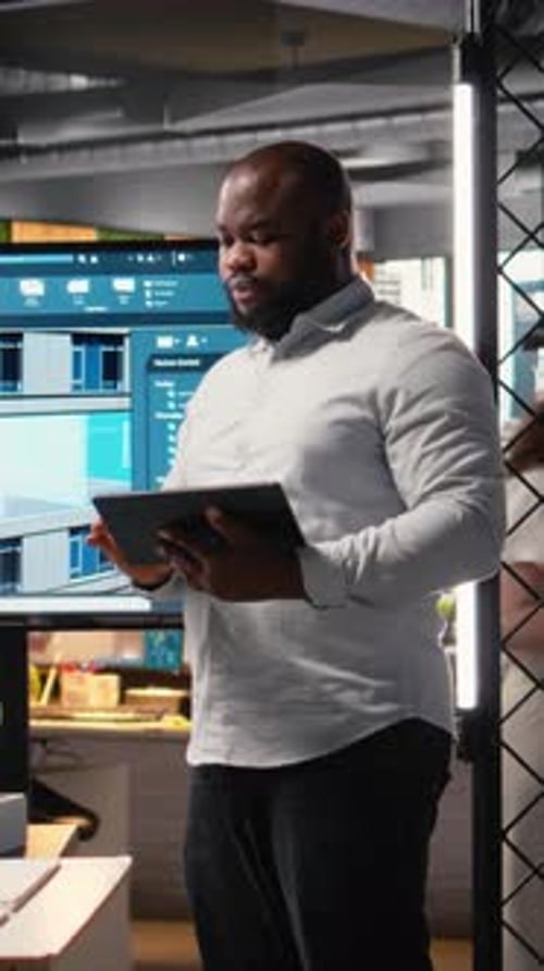 Vertical Video African American Real Estate Developer Reviews City Planning Layout on Laptop