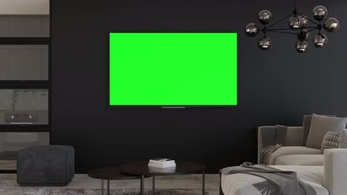 LED TV with blank green screen, hanging on the wall at home. TV video mock up with Chroma Key.