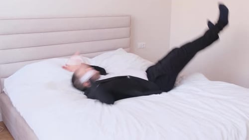 Falling Young Businessman on a White Bed