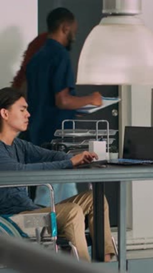 Vertikaler Videosoftware-Programmierer mit körperlicher Behinderung, der Code auf dem Computer schreibt
