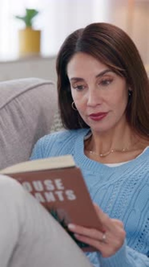 Woman Reads Book on Sofa at Home