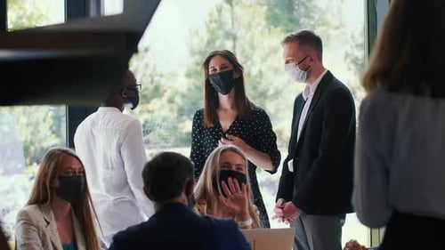 Group of Happy Young Smiling Business People Talking Working at Modern Office All Wearing COVID19