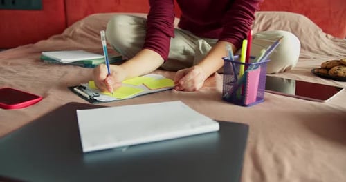 Person working on a project on their bed