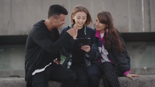 Friends Looking at Tablet and Laughing Together