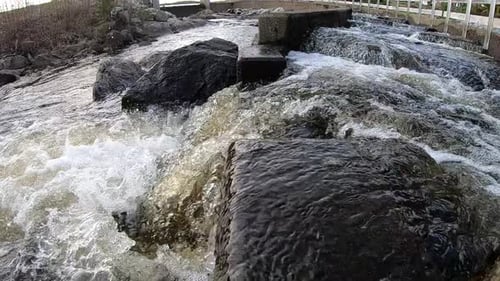 Super slow motion close up video with wide angle of water flowing down from the lake to river.