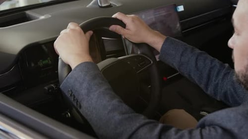 Man in Car Adjusting Steering Wheel Settings