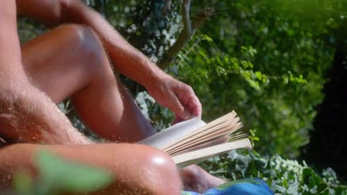 Mann liest Buch in der Wildnis