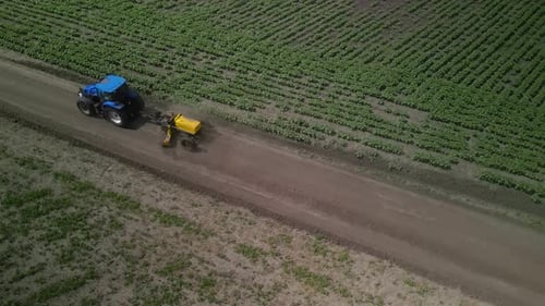 Der Grader arbeitet mit dem Traktor und ebnet die Feldstraße