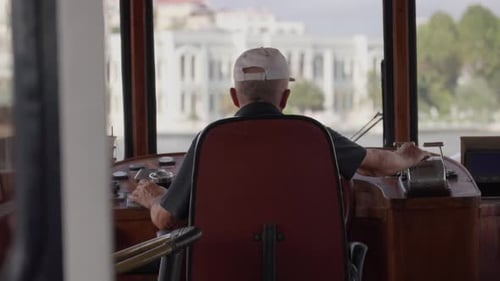Captain of commercial fishing vessel steers ship by turning steering wheel