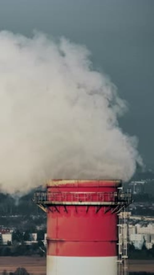 Pollution plume rising from industrial smokestack in urban area