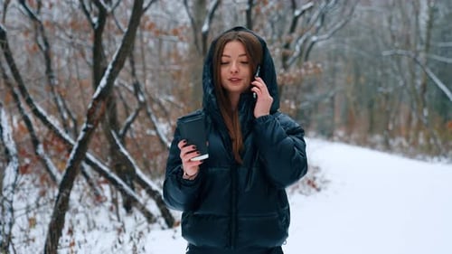 Woman Talking on Phone in Snowy Forest