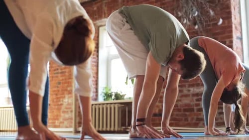 Fitness, Sport And Healthy Lifestyle Concept - Group Of People Making Yoga Exercises In Gym