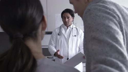 Arzt tröstet Paar mit Ratschlägen zur Familienplanung im Krankenzimmer