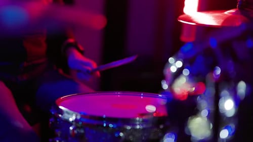 Drummer Plays Drums Under Red and Blue Lights