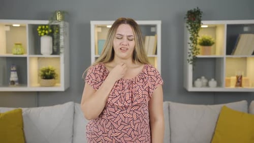 Woman Experiences Discomfort and Sore Throat Indoors