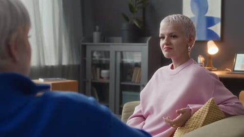 Two People Talking on Couch Indoors