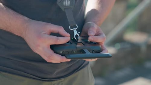 Man Hands Operating Drone Controller on Sunny Day