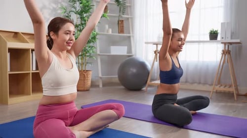 Two Women Practice Yoga in Bright Room